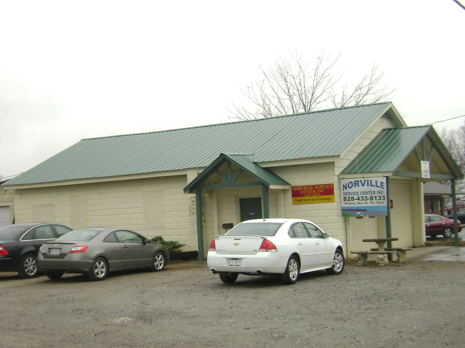 Green metal roof on a service garage with a covered entry in New London
